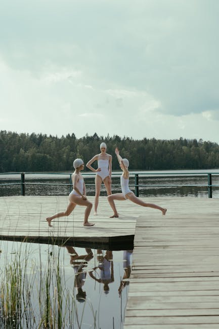 Woman meditating in a lotus position on a wooden pier by the lake, surrounded by nature